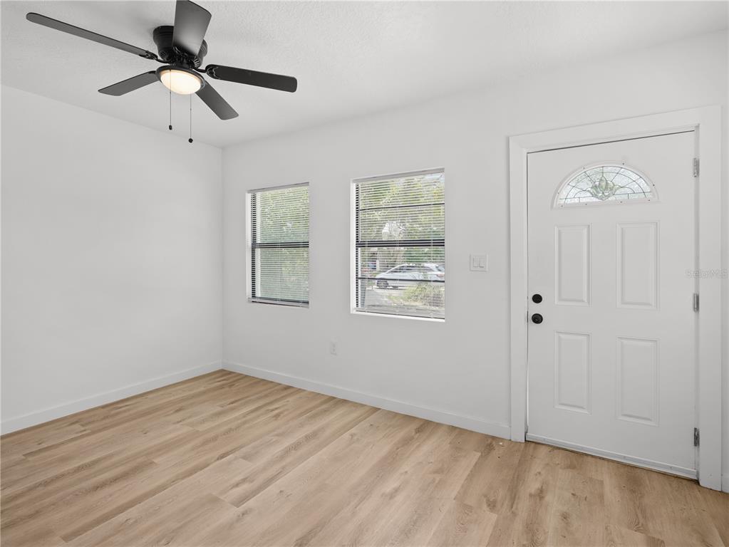 An empty room features light wood-look flooring, white walls, two windows, and a ceiling fan — 2181 LINDEN ROAD, WINTER PARK, FL