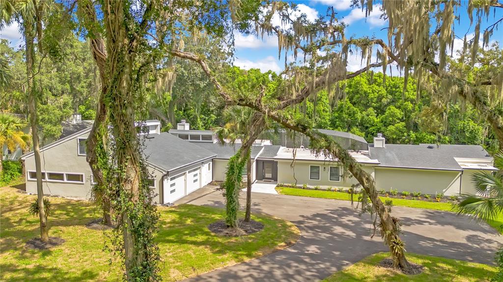An exterior view of a modern house with a gray roof and a paved driveway — 2317 FARMWOOD CIRCLE, GOTHA, FL