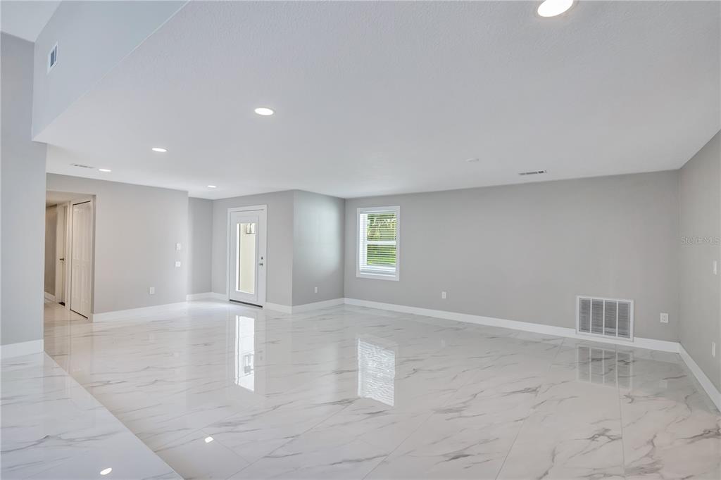 An empty room with white marble-look tile flooring, light gray walls, and recessed ceiling lighting — 2317 FARMWOOD CIRCLE, GOTHA, FL