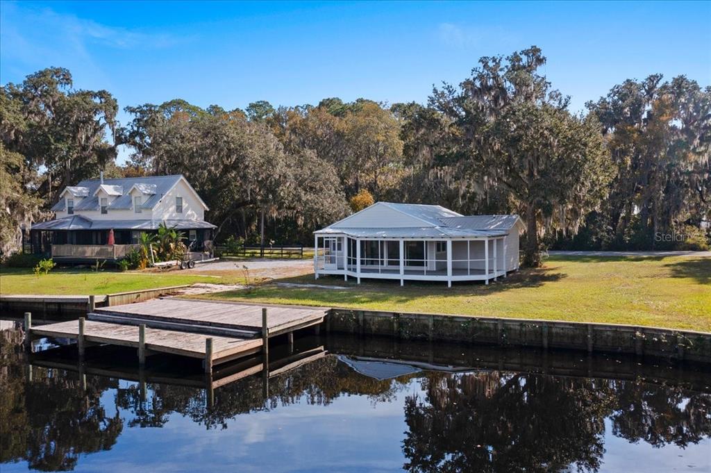 An aerial view shows two houses near a wooden dock on a calm waterfront — 13555 COUNTY ROAD 13, ST AUGUSTINE, FL