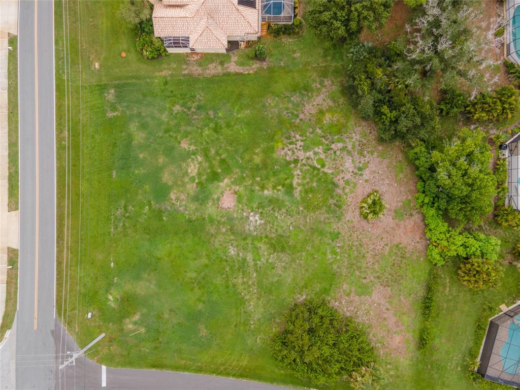 An aerial view shows a vacant, grassy residential lot bordered by a road and houses — 4200 CAPE HAZE DRIVE, PLACIDA, FL