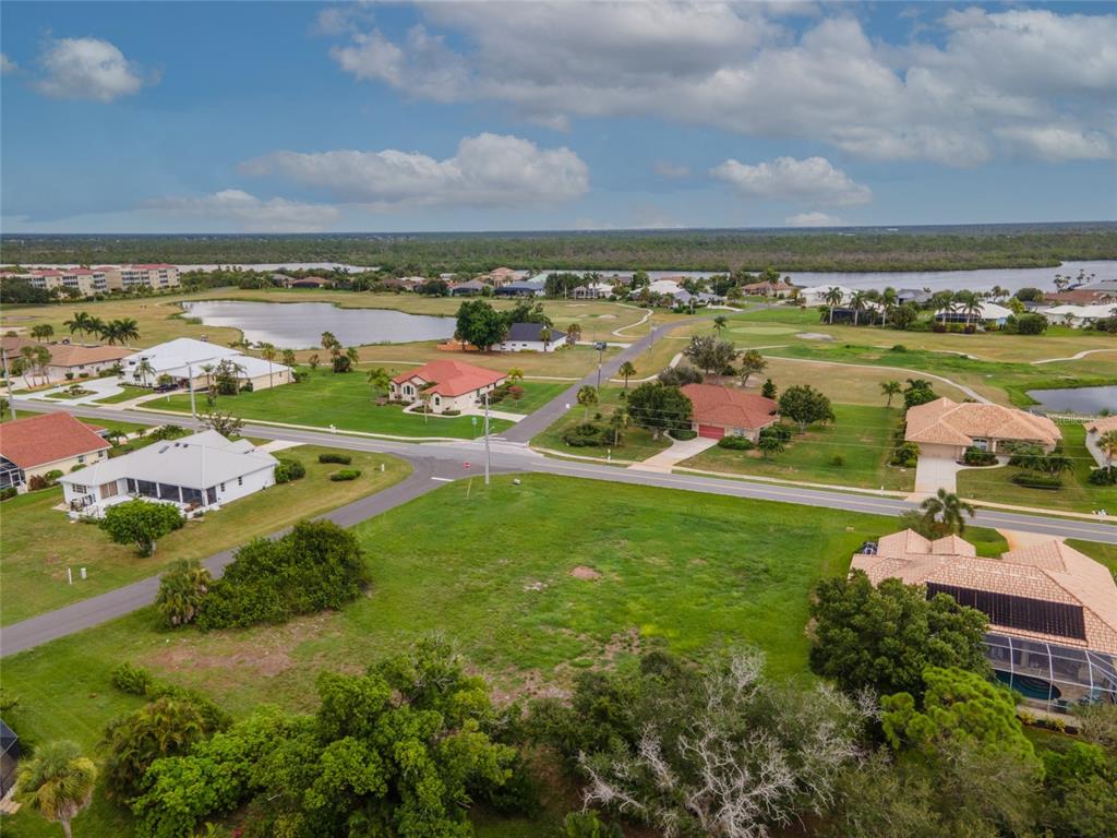 An aerial view shows a vacant grassy lot situated at a residential street intersection — 4200 CAPE HAZE DRIVE, PLACIDA, FL