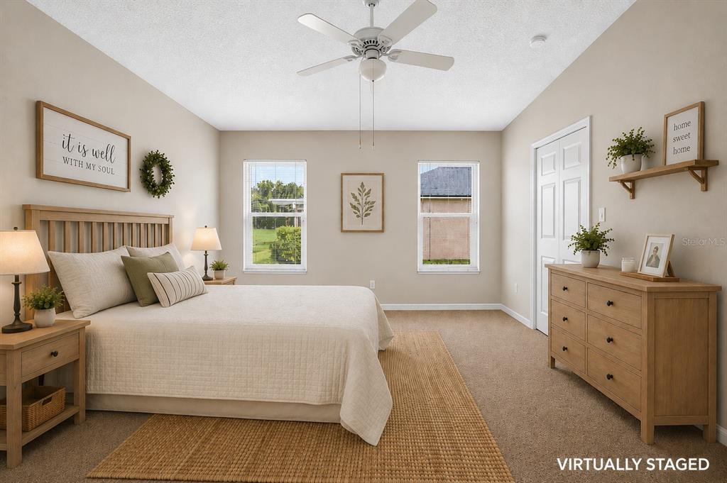 This bedroom features a bed, a dresser, two windows, and a ceiling fan — 535 SCARLET MAPLE COURT, PLANT CITY, FL