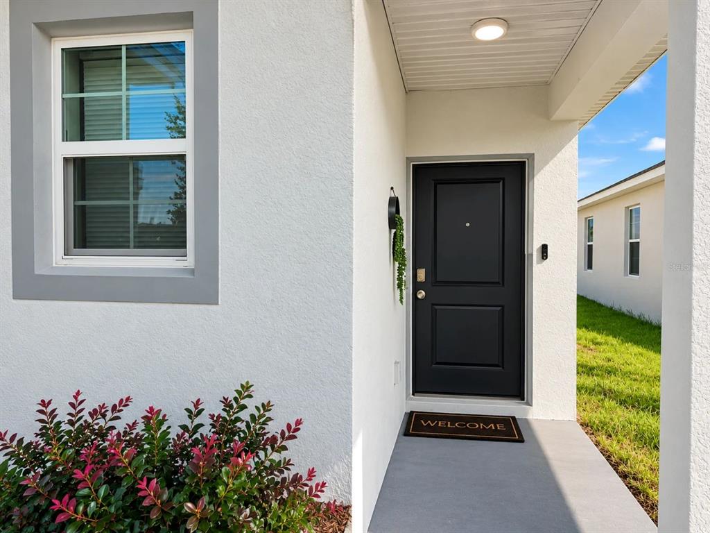 A single-story house with a white stucco exterior, a two-car garage, and a concrete driveway — 5539 MADDIE DRIVE, HAINES CITY, FL