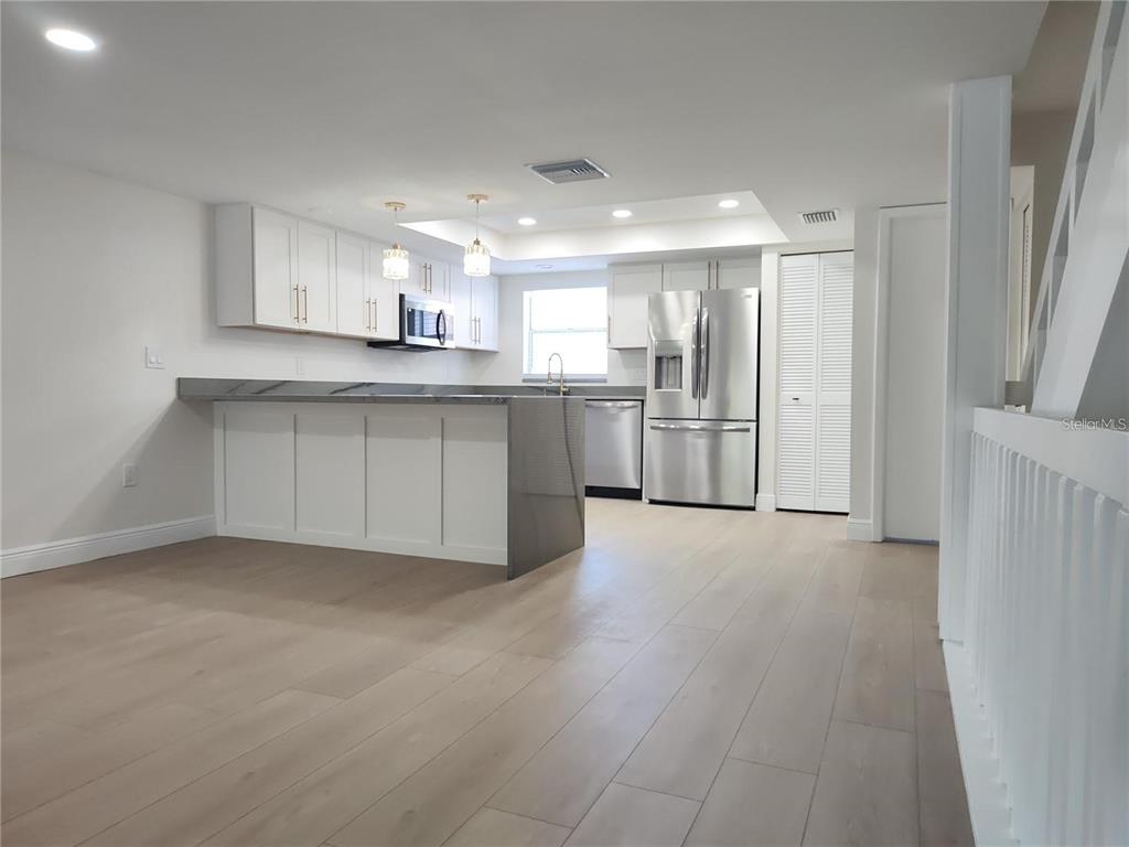 A multi-story townhouse exterior features a palm tree, a white garage door, and two windows — 255 CAPRI CIRCLE N UNIT 36, TREASURE ISLAND, FL