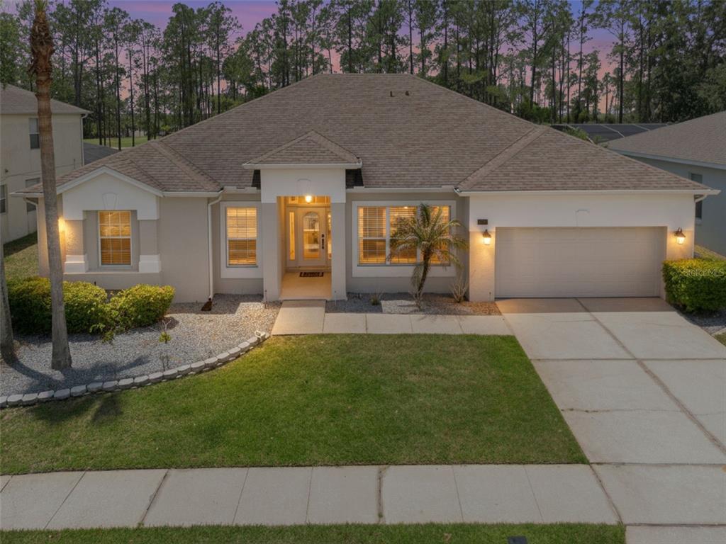 A single-story suburban house features a tan stucco exterior, a two-car garage, and a lawn — 259 NORTHAMPTON DRIVE, DAVENPORT, FL