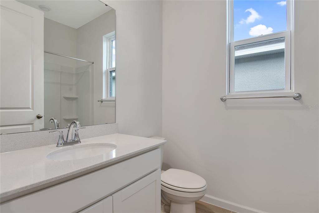 A bathroom features a white vanity with a sink, a mirror, and a window — 5347 MICKEY AVENUE, WINTER HAVEN, FL