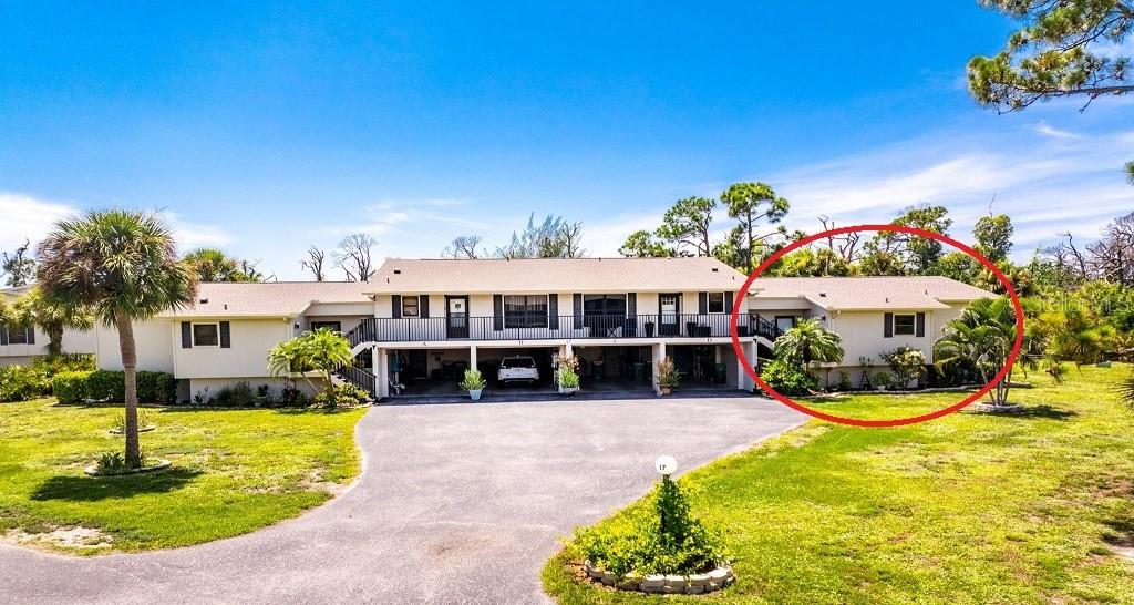 A two-story apartment building with a paved driveway and a red circle highlighting one unit — 4260 PLACIDA ROAD UNIT 17D, ENGLEWOOD, FL