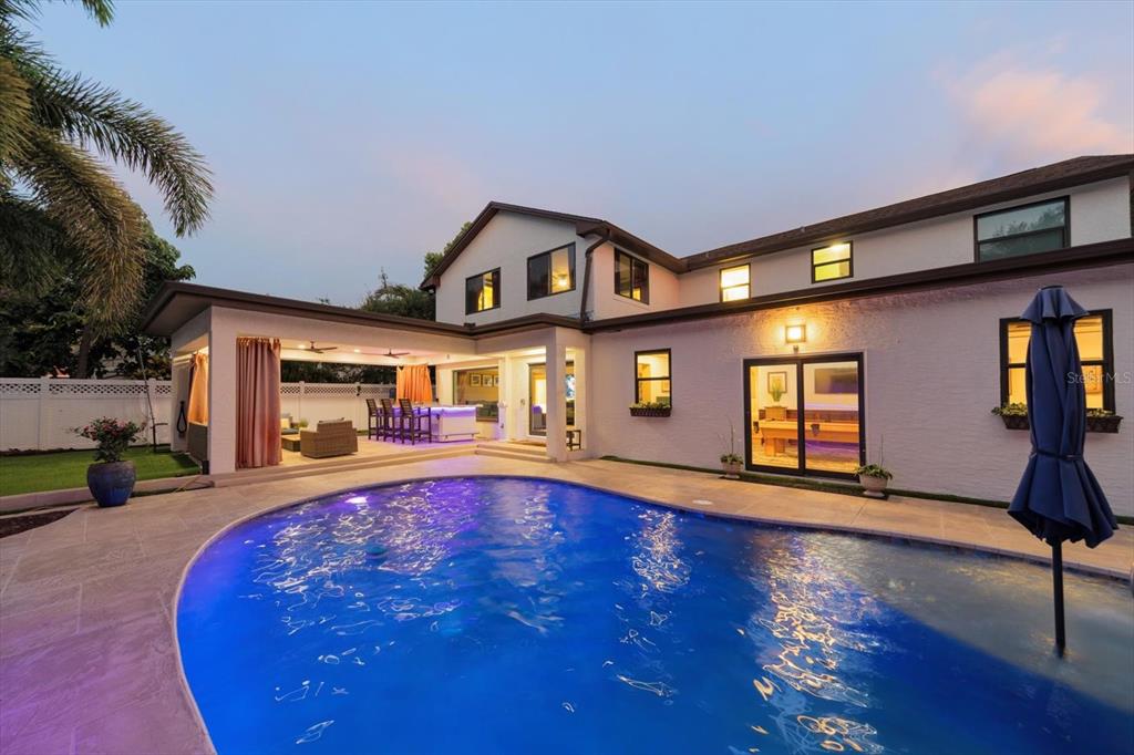 A two-story house exterior features a swimming pool, a covered patio, and a backyard area — 3005 SUNSET DRIVE, BELLEAIR BLUFFS, FL