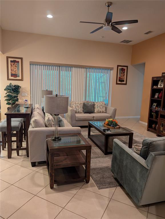 A living room features a sofa, armchairs, a coffee table, and a ceiling fan — 778 IRVINE RANCH ROAD, POINCIANA, FL