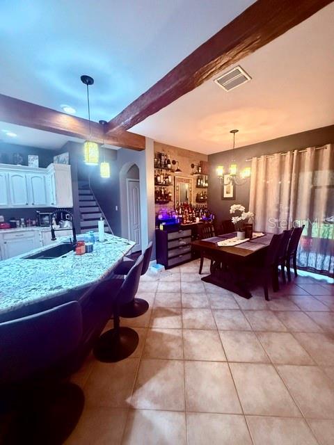 A kitchen with a granite island, bar stools, and a dining area with a home bar — 4346 WATERVILLE AVENUE, WESLEY CHAPEL, FL