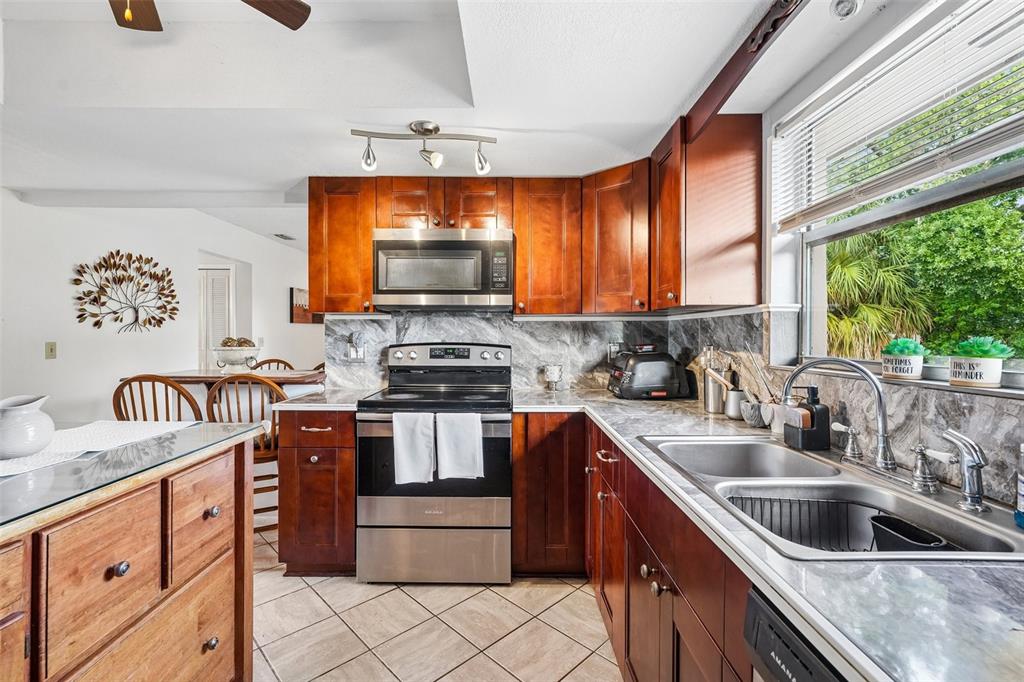 A living room with wood flooring, gray sofas, a coffee table, and a breakfast bar — 3777 PARKWAY BOULEVARD, LAND O LAKES, FL