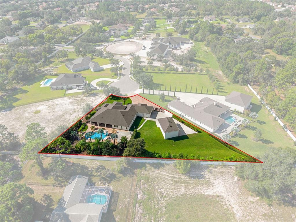 An aerial view shows a house with a pool and a detached garage on a lot — 533 STORYBOOK LANE, SPRING HILL, FL