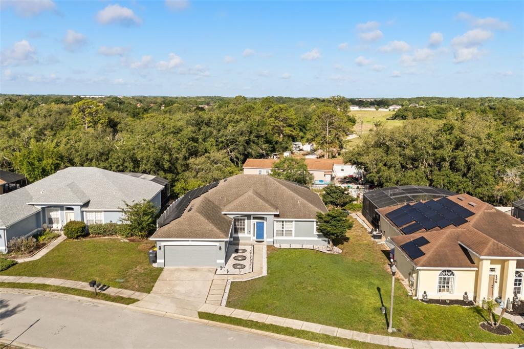 An aerial view shows a single-story suburban house with a gray roof and garage — 417 WILDFLOWER RD, DAVENPORT, FL