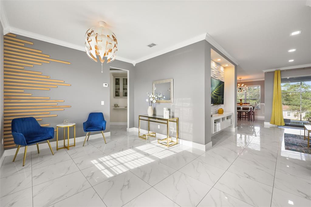 A bright living area features gray walls, wood slat accents, blue chairs, and white flooring — 417 WILDFLOWER RD, DAVENPORT, FL