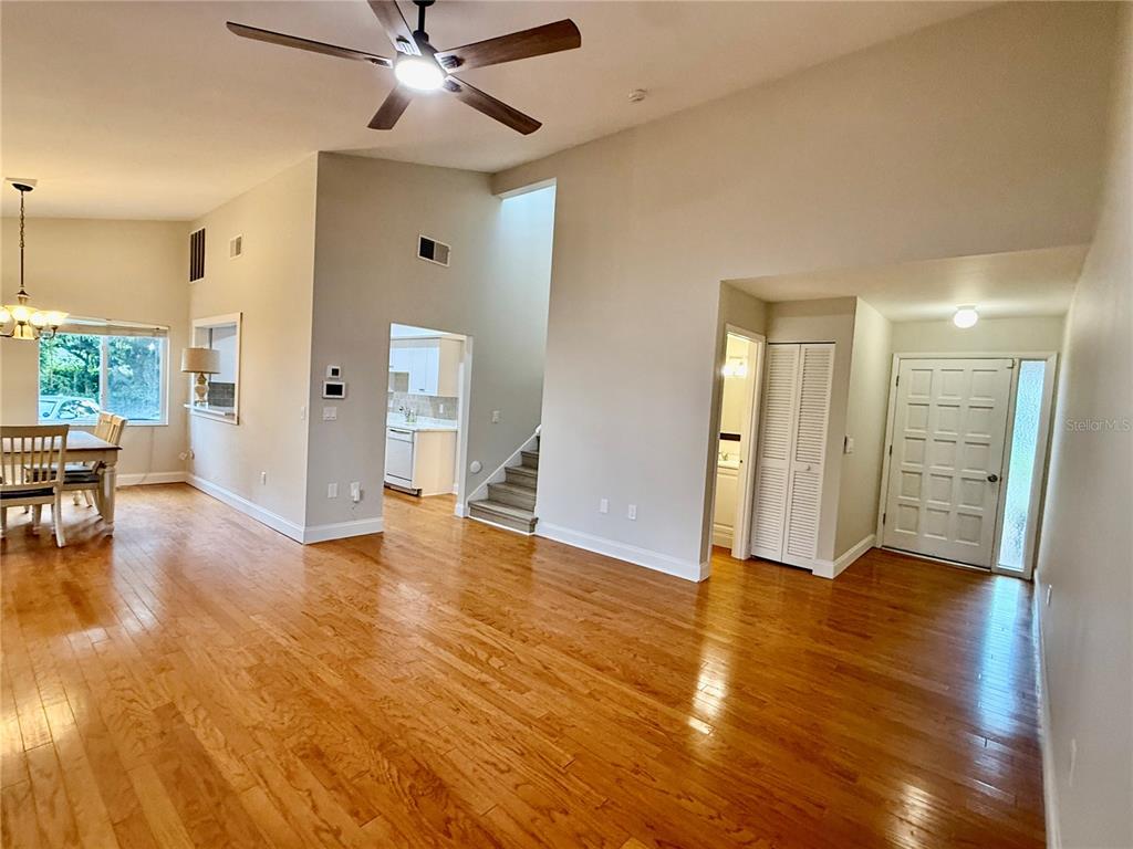 A living room with hardwood floors, a ceiling fan, and an adjacent dining area — 718 SORRENTO INLET DRIVE UNIT 718, NOKOMIS, FL