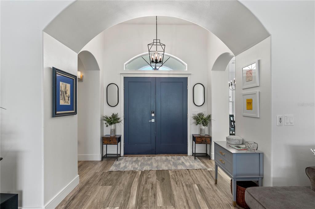 An entryway features a dark blue double door, arched ceiling, and wood-look flooring — 17 COLLINGTON COURT, PALM COAST, FL