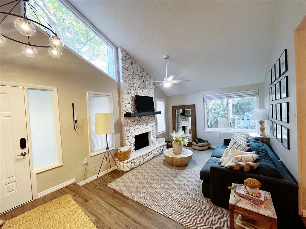 A white front door with a glass insert sits beside a screened-in porch area — 16 RAINTREE COURT, ORMOND BEACH, FL