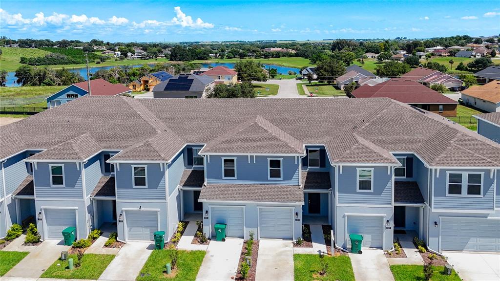 An aerial view shows a row of light blue townhouses with gray roofs and garages — 331 SOL VISTA DRIVE, DUNDEE, FL