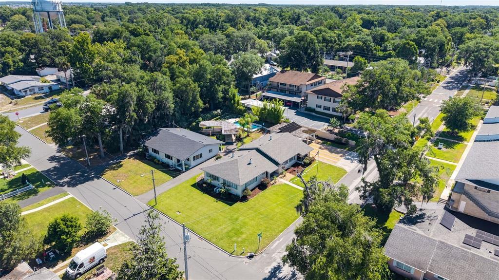 An aerial view shows a residential neighborhood with houses, trees, and a water tower — 1012 N BAKER STREET, MOUNT DORA, FL