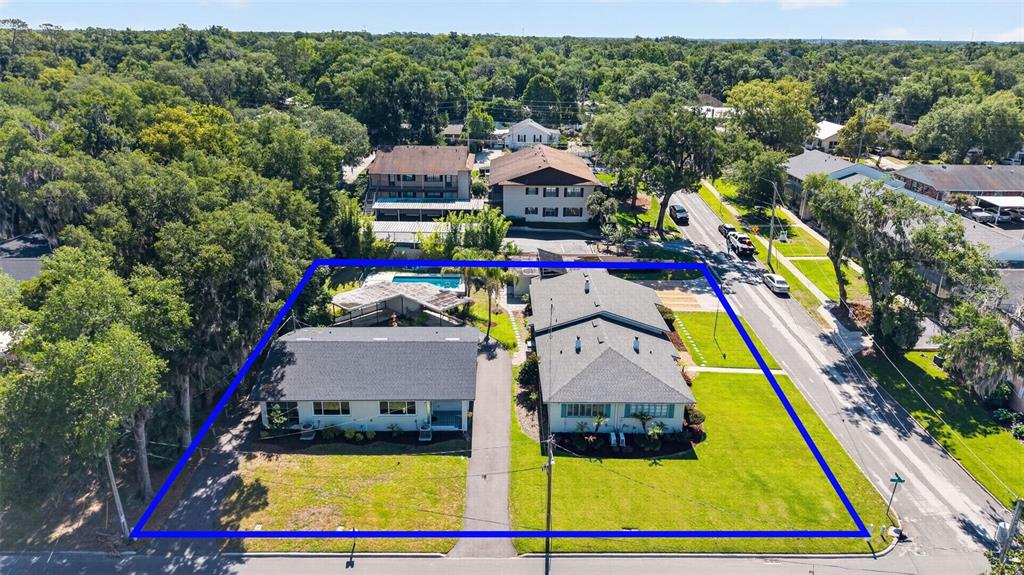 An aerial view shows two residential buildings on a lot with a pool and driveway — 1012 N BAKER STREET, MOUNT DORA, FL