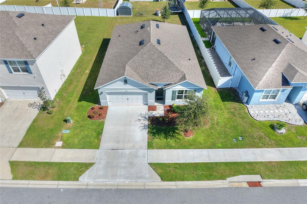 An aerial view shows a suburban house with a gray roof and a concrete driveway — 3645 DIVING DOVE LANE, BARTOW, FL