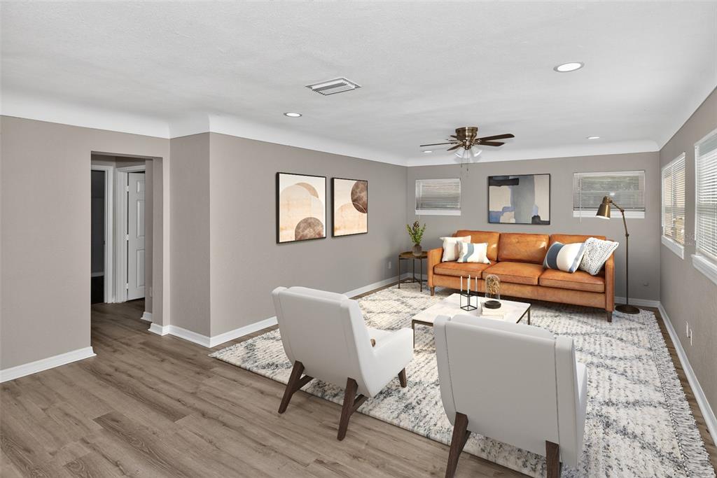 An empty room features gray walls, dark wood-look flooring, recessed lighting, and a white door — 5131 ARAGON WAY S, ST PETERSBURG, FL