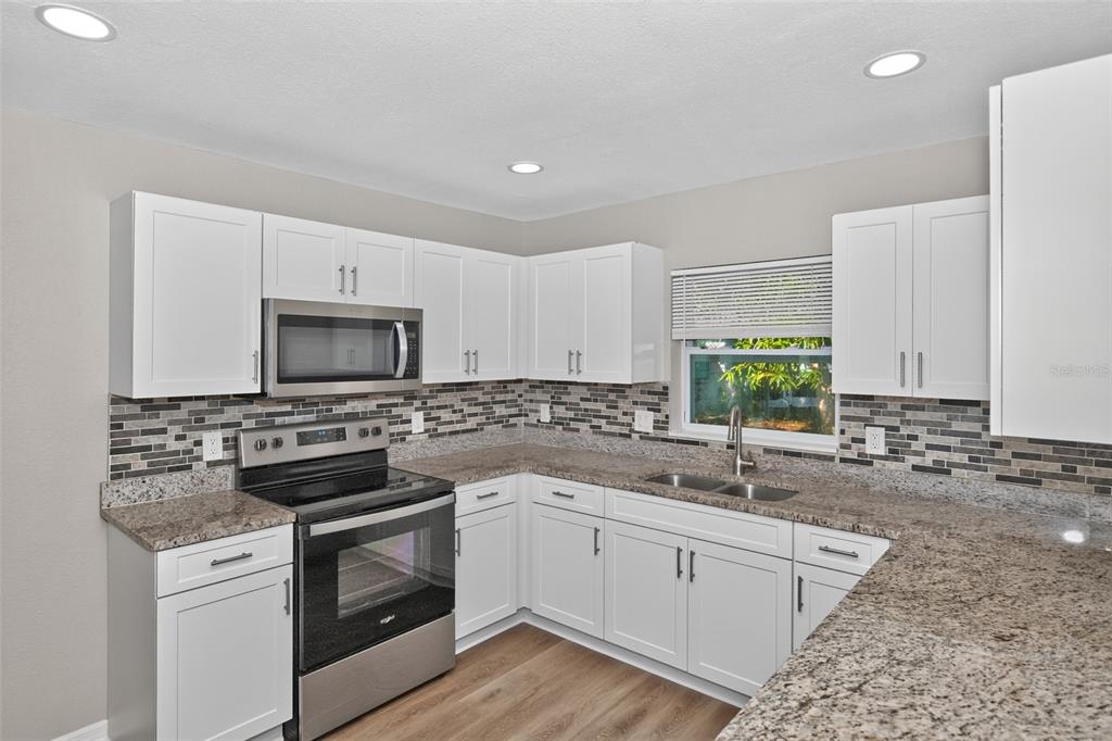 A bathroom features a white toilet, a dark wood vanity with a sink, and a mirror — 5131 ARAGON WAY S, ST PETERSBURG, FL