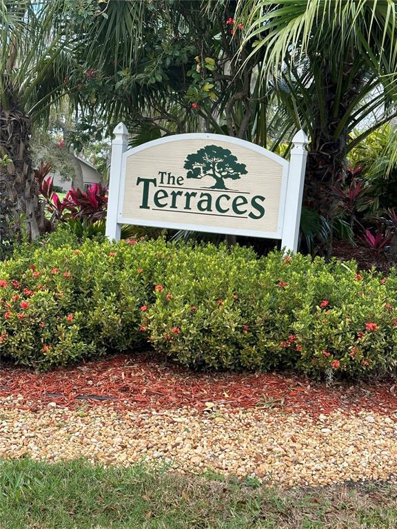 A sign reading The Terraces stands in front of a landscaped garden with palm trees — 6505 STONE RIVER ROAD UNIT 103, BRADENTON, FL