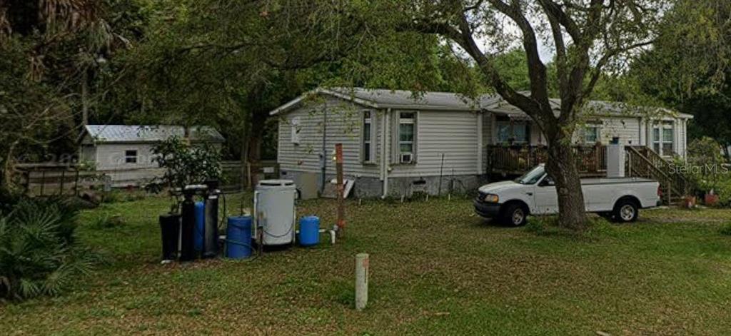 A light-colored manufactured home with a white pickup truck parked in the grassy front yard — 3926 NW 39TH AVENUE, OKEECHOBEE, FL
