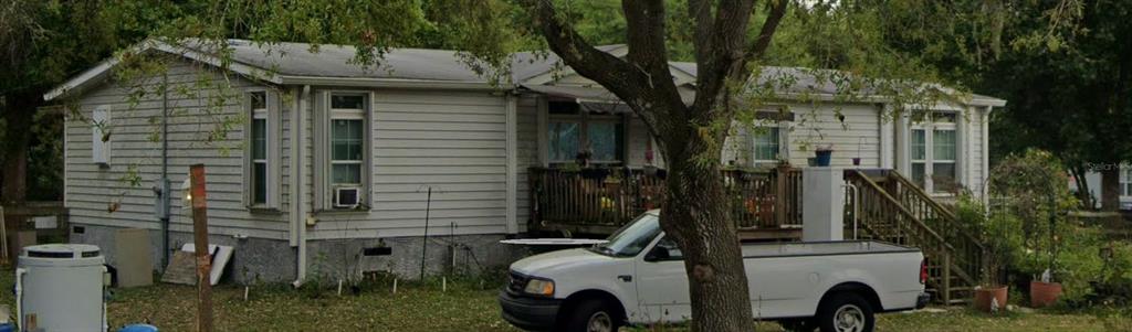 A light-colored mobile home with a wooden deck and a white pickup truck parked outside — 3926 NW 39TH AVENUE, OKEECHOBEE, FL