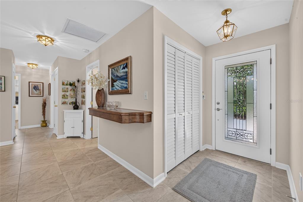An entryway features tile flooring, a white front door with glass, and a wall-mounted shelf — 802 SANDWEDGE DRIVE, NEW SMYRNA BEACH, FL