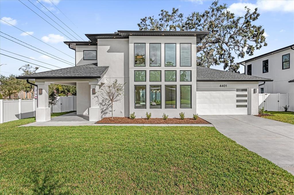 A modern two-story house features a white stucco exterior, large vertical windows, and a garage — 4401 ROCKLEDGE ROAD, ORLANDO, FL