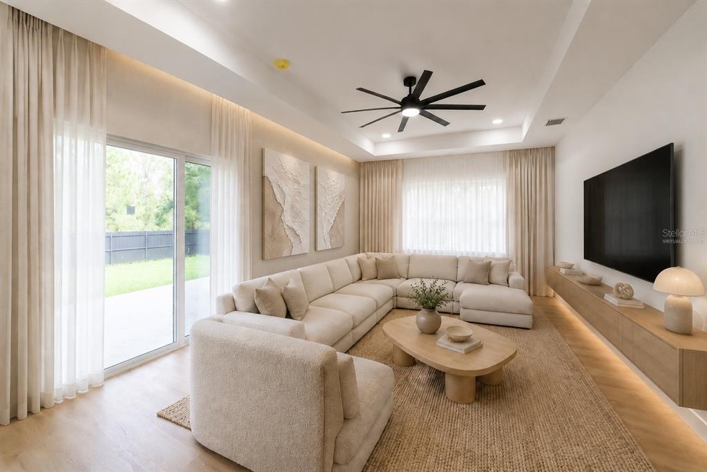 This living room features a large sectional sofa, a coffee table, and a wall-mounted television — 6308 NOTRE DAME TERRACE, NORTH PORT, FL