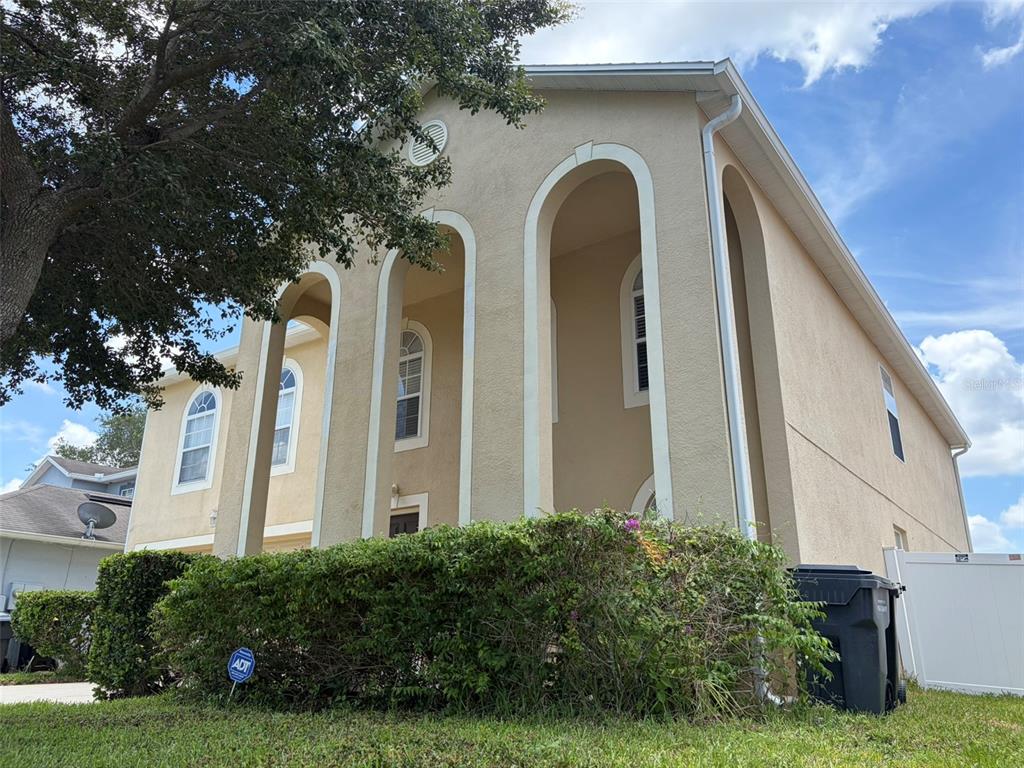 A two-story house with a stucco exterior, arched entryways, and a large front hedge — 247 BLAKE AVENUE, DAVENPORT, FL