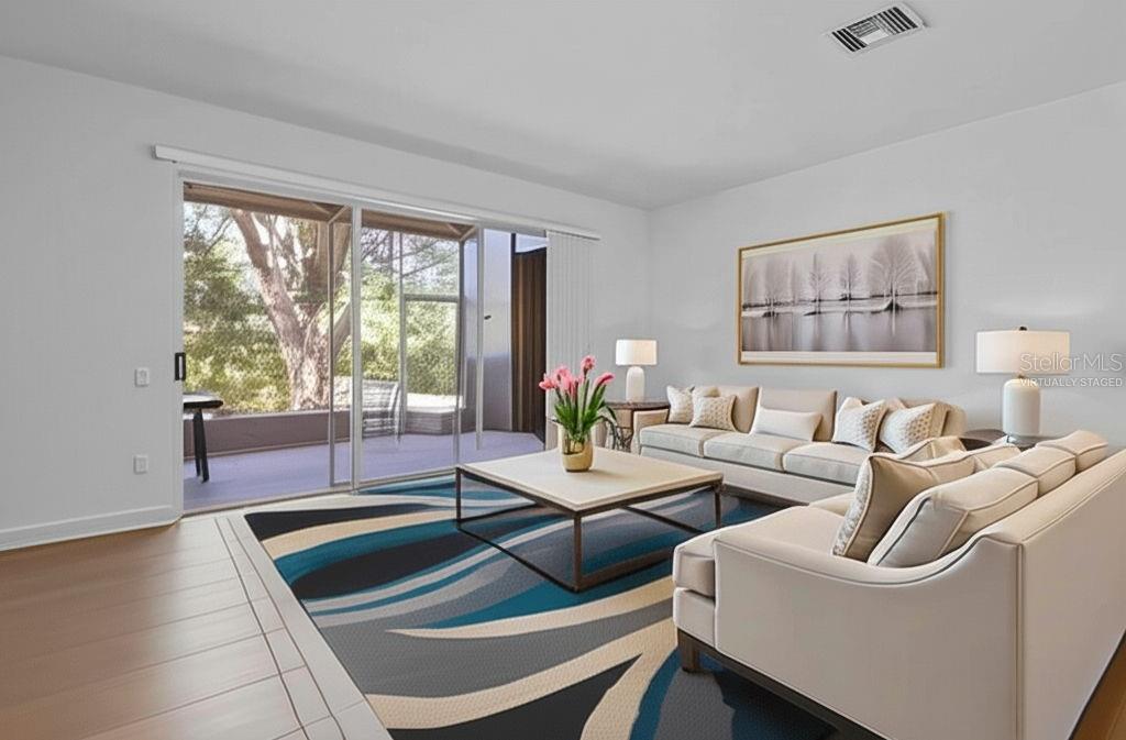 A living room with a large area rug, two sofas, and a sliding glass door — 2712 CONCH HOLLOW DRIVE, BRANDON, FL