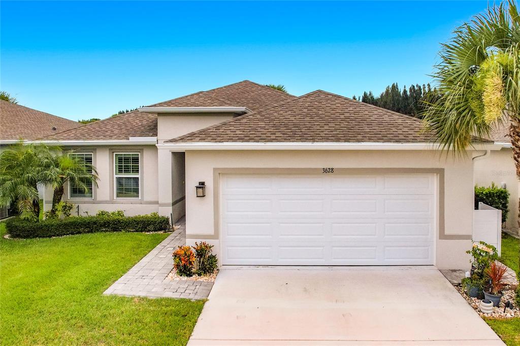 A living room with a beige sectional sofa opens into a kitchen with dark cabinets — 3628 SAPPHIRE HOLLOW WAY, FORT PIERCE, FL