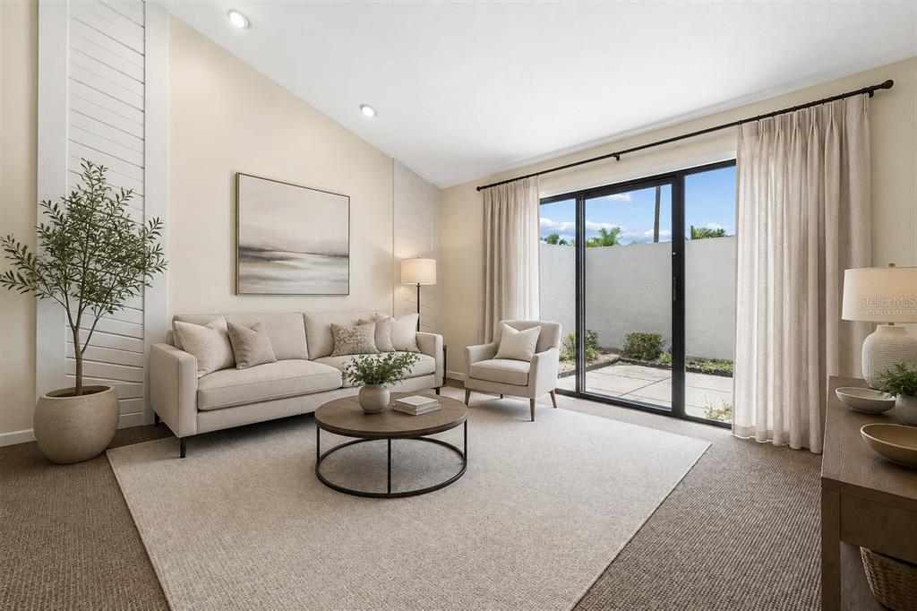 A living room features beige walls, brown carpeting, a vaulted ceiling, and a pink sofa — 4243 OAK LOOP UNIT 35, MULBERRY, FL