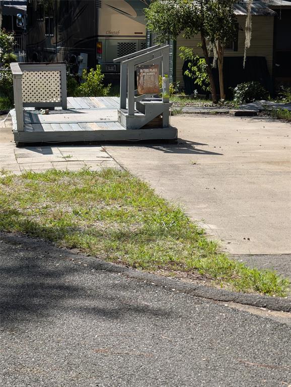 A small, elevated wooden deck with stairs and a lattice railing sits on a concrete pad — 25225 NE 141ST LANE NE, SALT SPRINGS, FL
