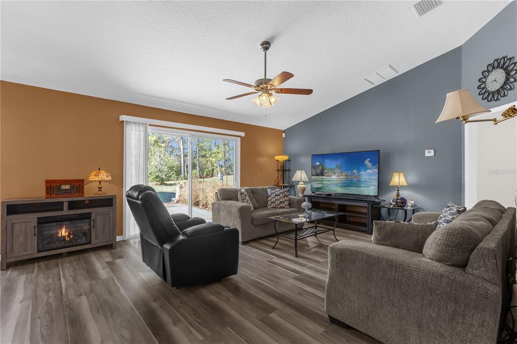 A kitchen with white cabinets, dark countertops, and a white stove next to a dining area — 8506 SW 136TH LOOP, OCALA, FL