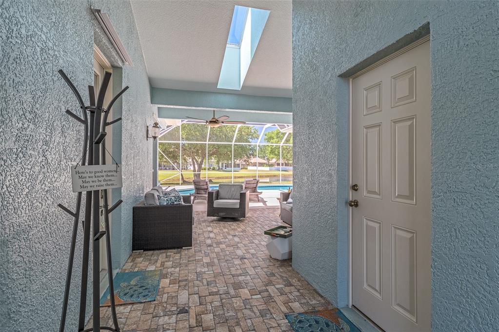 A covered patio features a skylight, a ceiling fan, and a view of a pool — 230 RIDGEMONT CIRCLE, PALM BAY, FL