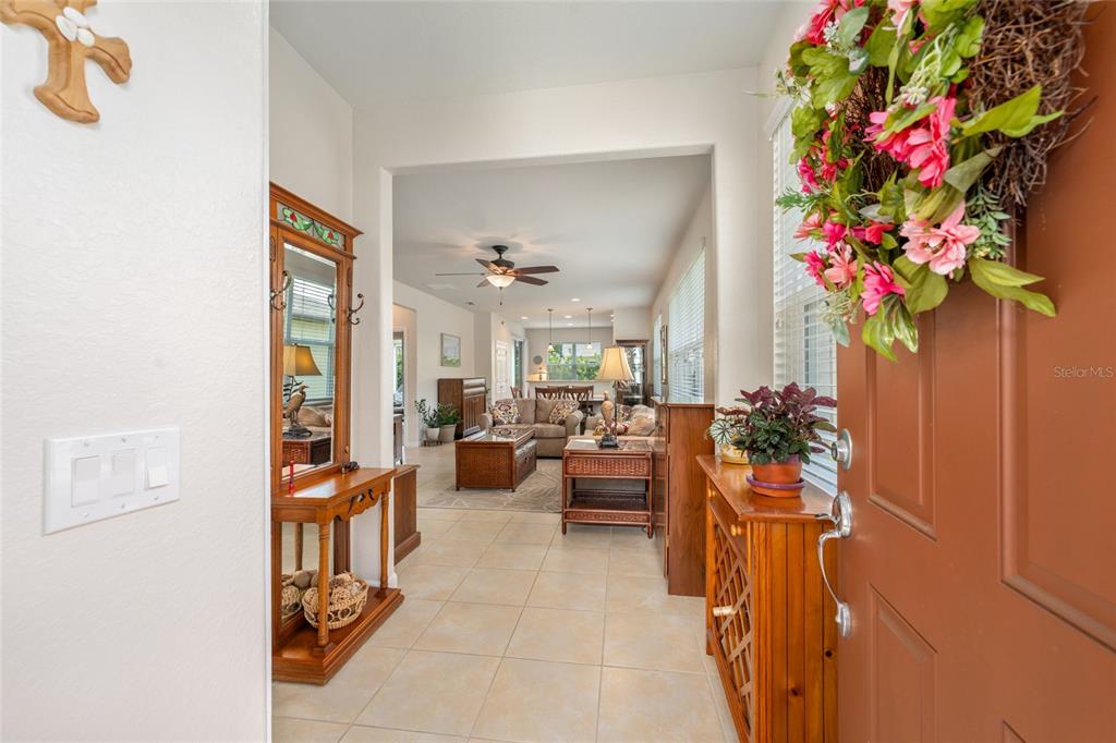 An entryway leads into a living room with tile flooring, a ceiling fan, and furniture — 9098 SW 70TH LOOP, OCALA, FL