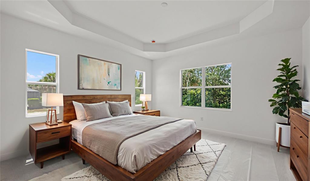 A bedroom features a wooden bed frame, two nightstands, a large plant, and tray ceilings — 11540 VERANDAH PALM COURT, FORT MYERS, FL