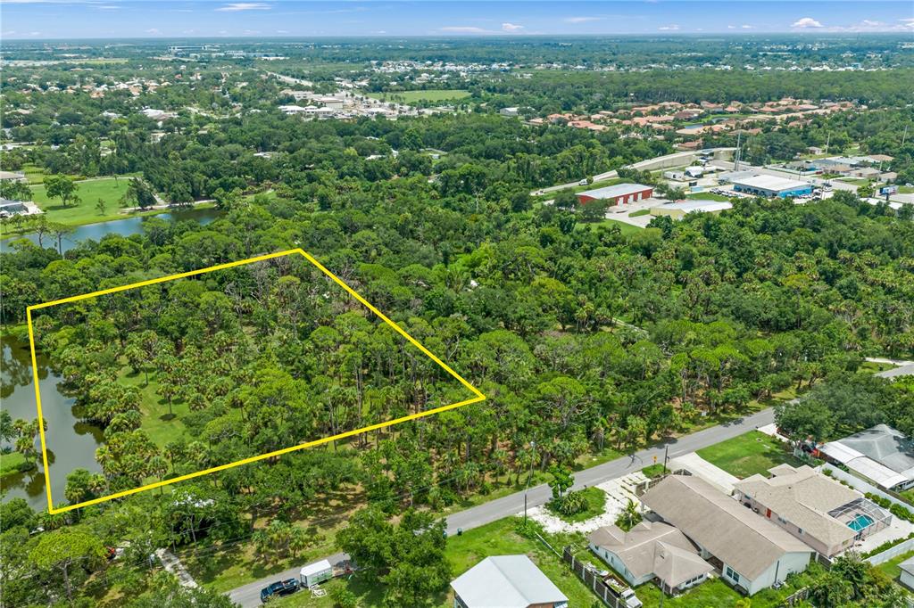 An aerial view shows a wooded lot outlined in yellow next to a residential street — TWIN LAKES AVENUE UNIT B1, NOKOMIS, FL
