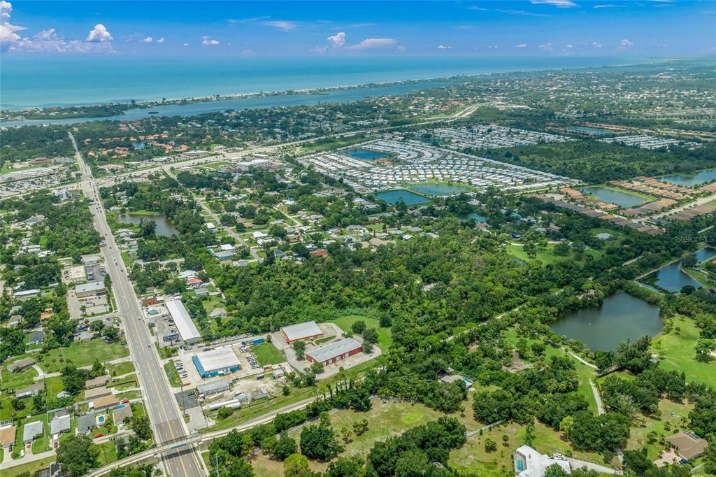 An aerial view shows a coastal landscape with a road, residential areas, and several ponds — TWIN LAKES AVENUE UNIT B1, NOKOMIS, FL