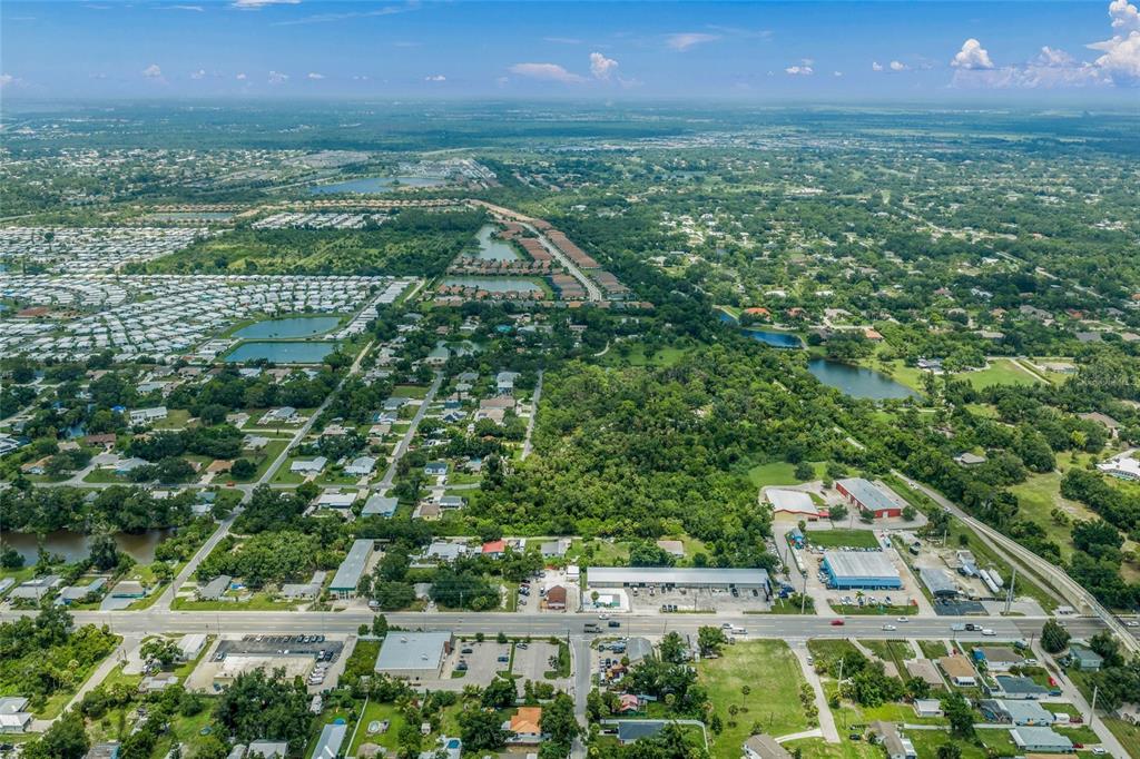 An aerial view shows a suburban landscape with houses, commercial buildings, and several small lakes — TWIN LAKES AVENUE UNIT B1, NOKOMIS, FL