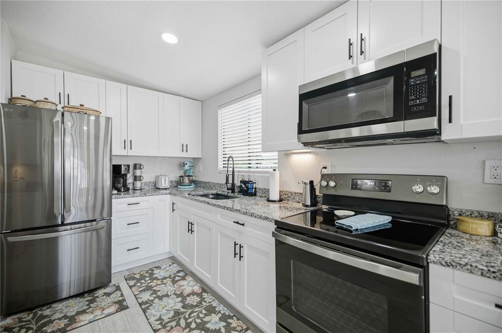 A kitchen with white cabinets, stainless steel appliances, and granite countertops — 8385 N SHADY FORK WAY, DUNNELLON, FL