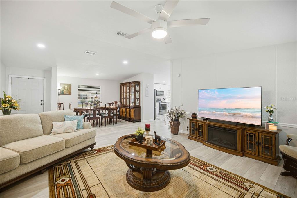 A living room features a beige sofa, a glass-topped coffee table, and a television console — 8385 N SHADY FORK WAY, DUNNELLON, FL