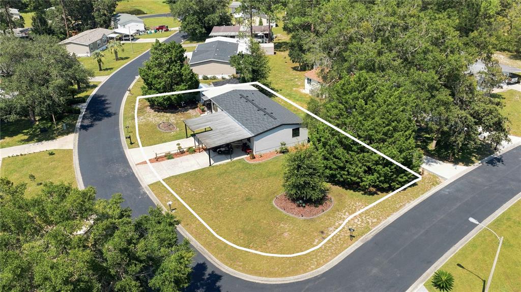 An aerial view shows a single-story house with a metal carport on a corner lot — 8385 N SHADY FORK WAY, DUNNELLON, FL