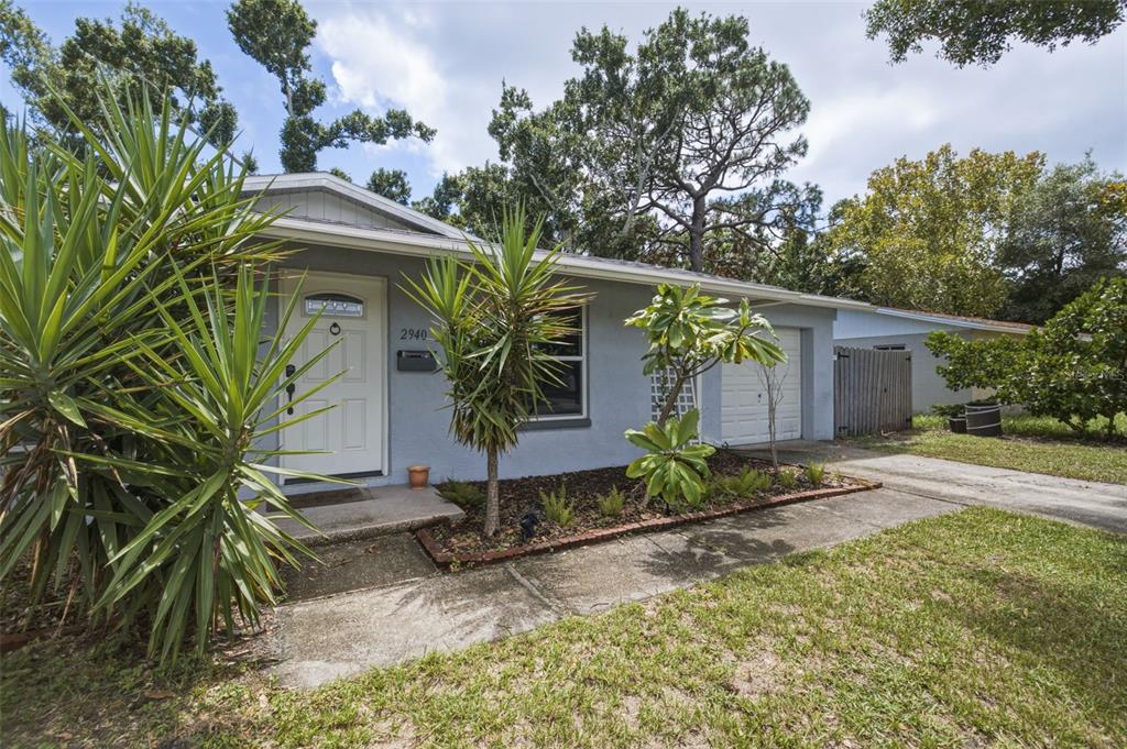 A single-story gray house features a front door, a garage, and a landscaped yard — 2940 47TH AVENUE S, ST PETERSBURG, FL